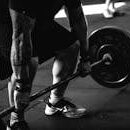 A powerful black and white image of a man deadlifting in a gym, showcasing strength and fitness.